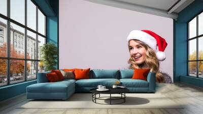 Close up portrait girl in Christmas Santa hat isolated on white background Wall mural